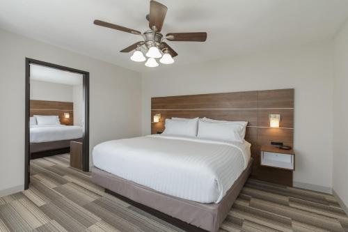 a bedroom with a large bed and a ceiling fan at Holiday Inn Express & Suites - South Bend - Notre Dame Univ. in South Bend