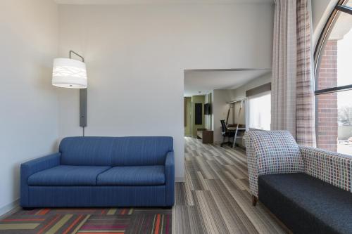 a living room with a blue couch and a chair at Holiday Inn Express & Suites - South Bend - Notre Dame Univ. in South Bend