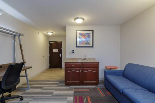 a living room with a blue couch and a desk at Holiday Inn Express & Suites - South Bend - Notre Dame Univ. in South Bend