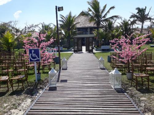 Hotel Rota do Sol في غواراتوبا: ممشى يؤدي لمكان الافراح بالورود الزهرية