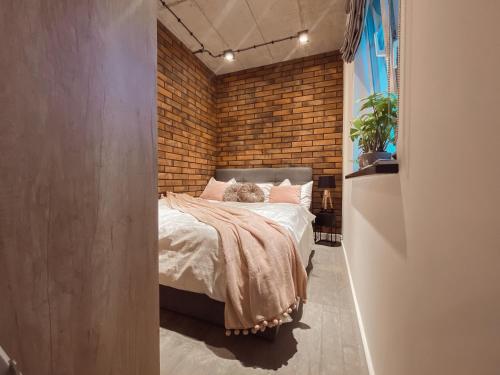 a bedroom with a brick wall and a bed at THE LOFT - Garncarska 1 in Piotrków Trybunalski
