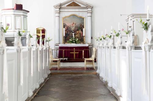 a altar in a church with a table and chairs at Dragsholm Slot in Hørve
