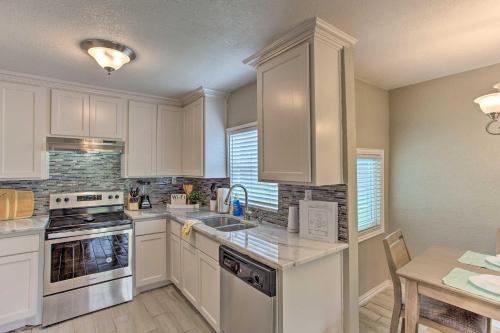 a kitchen with white cabinets and a sink and a table at Walk to ATandT Stadium Arlington Home with Yard! in Arlington