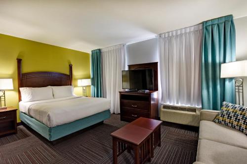pokój hotelowy z łóżkiem i kanapą w obiekcie Staybridge Suites Guelph, an IHG Hotel w mieście Guelph