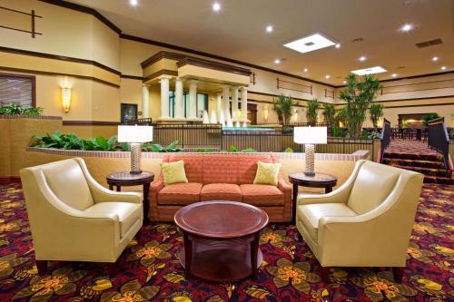 a living room with couches, tables and chairs at Holiday Inn Cincinnati-Eastgate, an IHG Hotel in Eastgate
