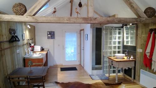 cocina con suelo de madera y mesa en La cabane sur l'eau, en Cul-des-Sarts