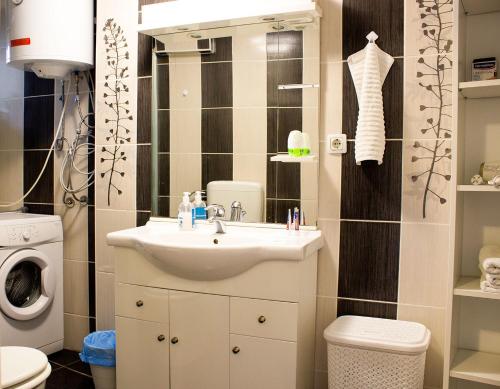 een badkamer met een wastafel en een wasmachine bij Zagreb Creative Apartments APP 2 in Zagreb