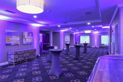 a room with purple walls and tables and a bowling alley at Voco The Clair Cincinnati Downtown by IHG in Cincinnati