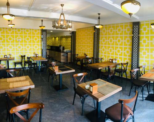 a restaurant with tables and chairs and yellow walls at Theodian Hotel in Istanbul