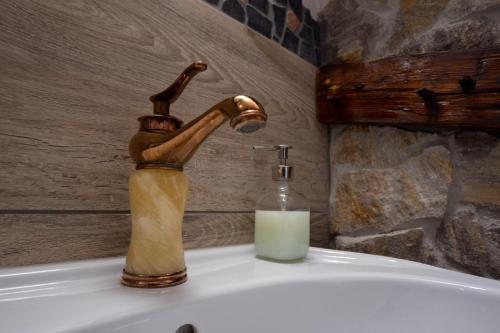 um lavatório de casa de banho com uma torneira e uma vela em Almhaus Dachsteinblick am Feuerkogel em Ebensee