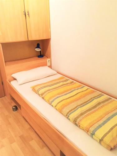 a bed with a striped blanket on it in a room at Ferienwohnung Bechter in Hittisau