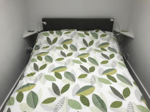 uma cama com um edredão verde e branco em Daisy Cottage em Saint Monance