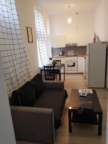 a living room with a couch and a kitchen at SouvenirAppart Wilenska in Bydgoszcz