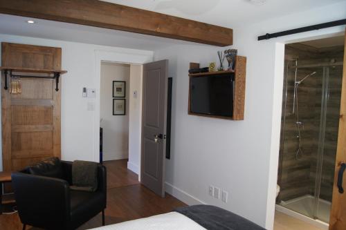 a bedroom with a bed and a television on a wall at Restaurant et Gite Les Passionnés in Val-David