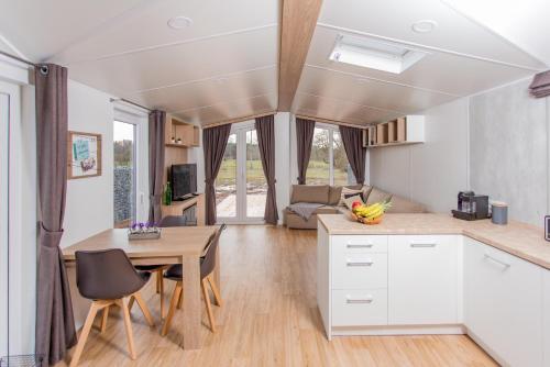 a kitchen and living room with white cabinets and a table at Fidelios Appartements in Pressath