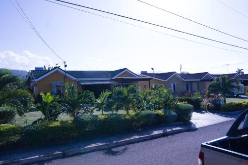 a house with palm trees in front of it at Sweet Holiday Haven in Ocho Rios