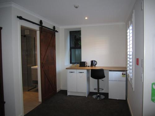 a kitchen with a counter and a stool in a room at The Stables Dunedin in Dunedin