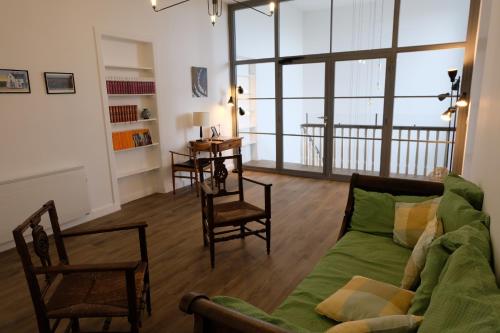 a living room with a green couch and chairs at Maison d'hôtes Le 90 in Armentières