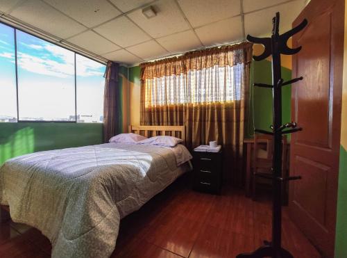 Un dormitorio con una cama y una ventana grande. en Hospedaje Manchego's, en Huancayo