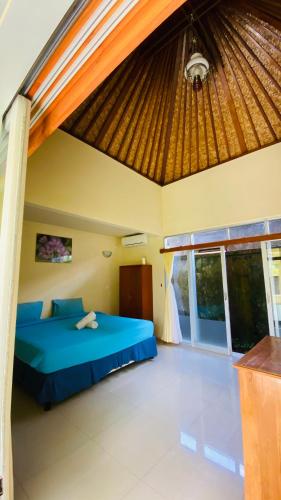 a bedroom with a blue bed in a room at Pandawa Beach Homestay in Uluwatu