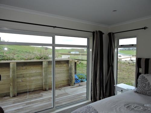 a bedroom with a bed and a sliding glass door at 5 Acres B&B in Tokoroa