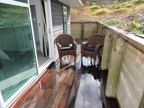 two chairs sitting on the porch of a house at 5 Acres B&B in Tokoroa