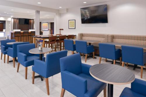 a waiting room with blue chairs and tables at Holiday Inn Express Wixom by IHG in Wixom