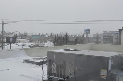 a view of a snow covered city from a window at Airport Traveller's Inn in Calgary