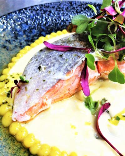 a plate of food with a piece of fish and vegetables at Botaniq Hotel Boutique in Mojácar
