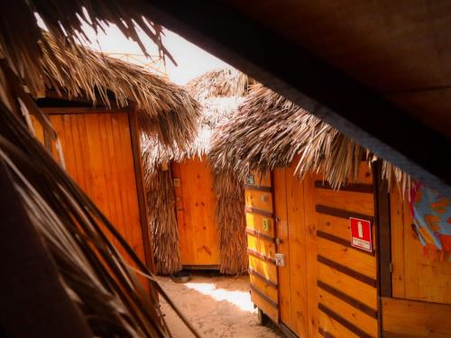a row of wooden huts with thatched roofs at Raiz Kite Cabana in Jericoacoara