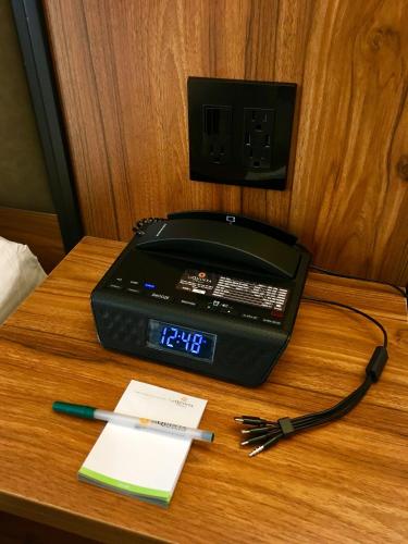 a clock on top of a table with a telephone at La Quinta by Wyndham Time Square South in New York