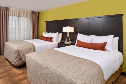 Staybridge Suites Merrillville, an IHG Hotel tesisinde bir odada yatak veya yataklar