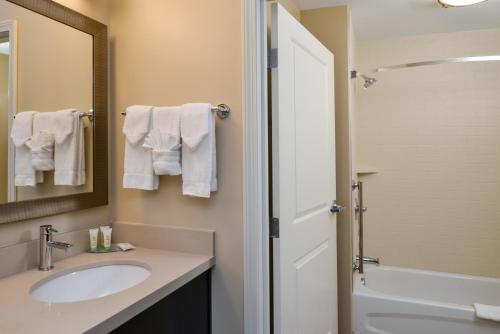 a bathroom with a sink and a shower with towels at Staybridge Suites Merrillville by IHG in Merrillville