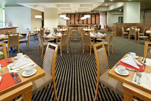 a dining room with tables and chairs in a restaurant at Crowne Plaza Monterrey Aeropuerto by IHG in Monterrey
