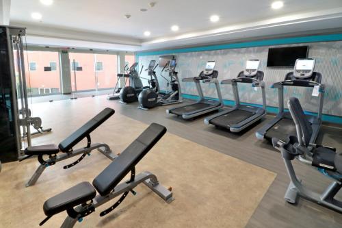 a gym with rows of treadmills and ellipticals at Crowne Plaza Monterrey Aeropuerto by IHG in Monterrey