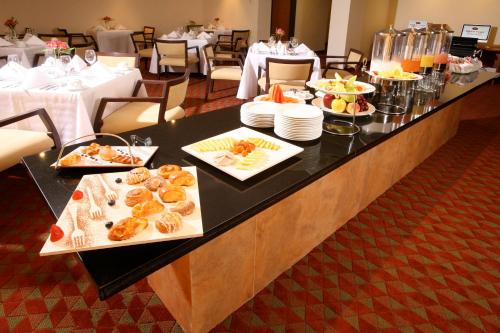 a buffet line with appetizers and plates of food at Crowne Plaza Monterrey Aeropuerto by IHG in Monterrey