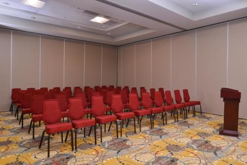 a conference room with red chairs and a podium at Crowne Plaza Shenandoah - The Woodlands Area by IHG in The Woodlands