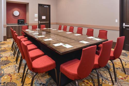 a conference room with a long table and red chairs at Crowne Plaza Shenandoah - The Woodlands Area by IHG in The Woodlands