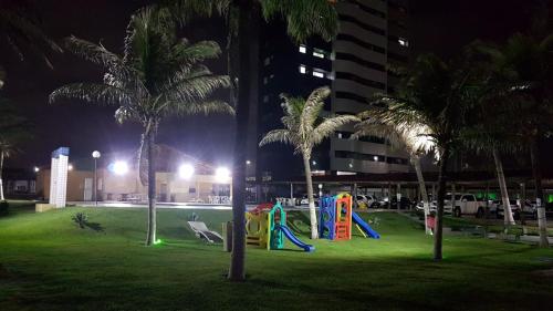 a park with a playground with palm trees at night at Apto Vista Beira Mar - Praia do Futuro a 100 mt da Praia in Fortaleza