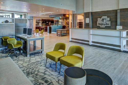 a waiting room with chairs and a desk with a computer at Holiday Inn Hotel & Suites - Houston West - Katy Mills by IHG in Katy
