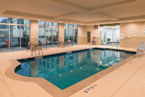 a large swimming pool in a hotel lobby at Holiday Inn Hotel & Suites - Houston West - Katy Mills by IHG in Katy