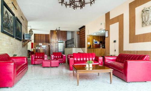 a living room with red couches and a table at Hotel María Teresa in Salamanca