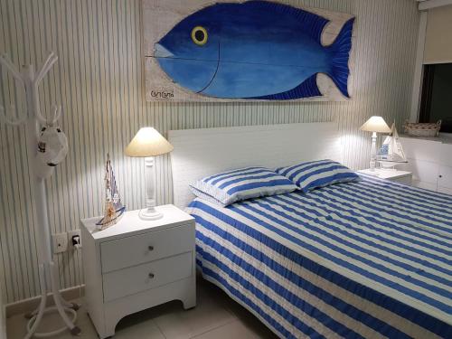 una camera da letto con un grande dipinto di un pesce blu sul muro di Carneiros Beach Resort Tamandaré Flat a Tamandaré