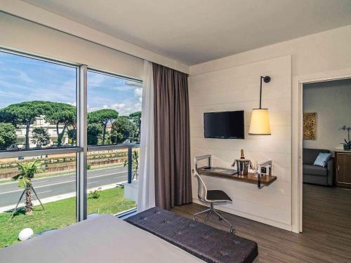 a hotel room with a bed and a desk and a window at Hotel Viareggio in Viareggio