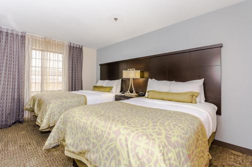 Staybridge Suites Grand Forks, an IHG Hotel tesisinde bir odada yatak veya yataklar