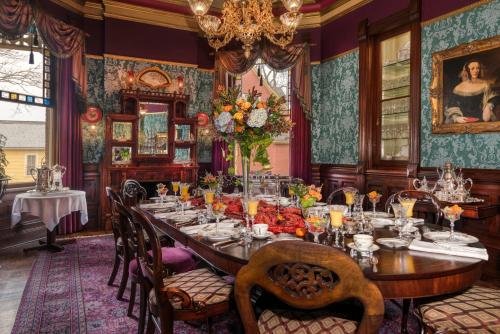 a dining room with a long table and a chandelier at The Empress of Little Rock in Little Rock