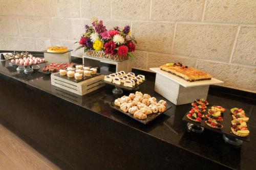 a buffet with many different types of pastries and cakes at Holiday Inn Queretaro Centro Historico by IHG in Querétaro