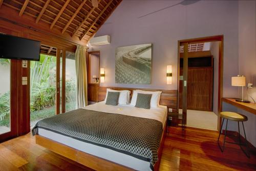 a bedroom with a bed and a television in a room at Temuku Villas Ubud - CHSE Certified in Ubud