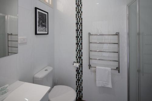 a white toilet sitting next to a white sink at Merivale Motel in Tumut