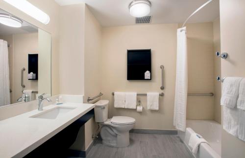 y baño con aseo, lavabo y ducha. en Candlewood Suites - Miami Exec Airport - Kendall, an IHG Hotel, en Kendall